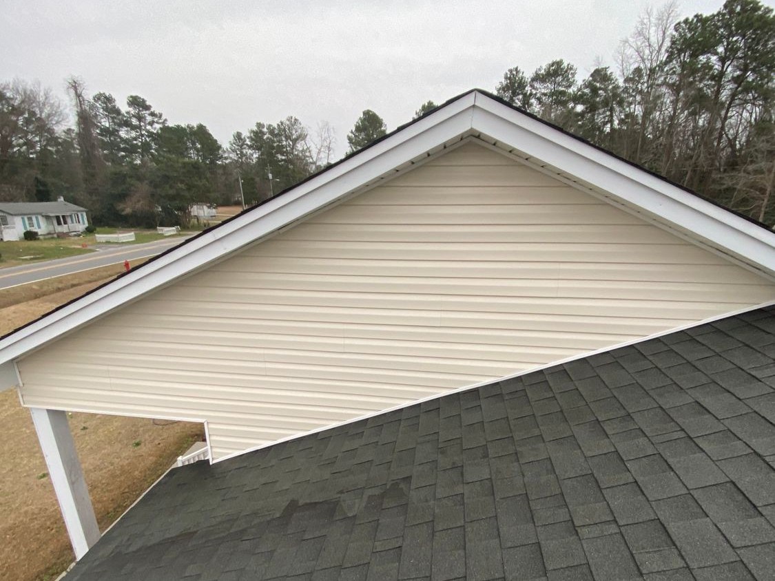The same cream gable and shingle roof after soft washing, algae gone